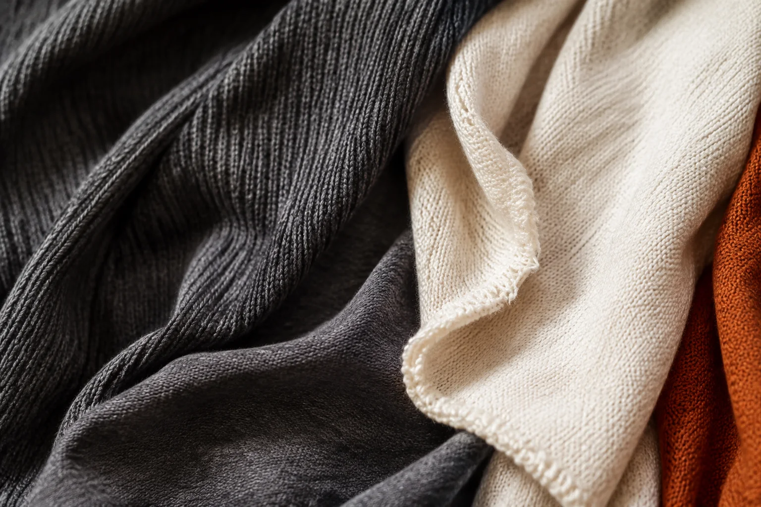 Illustrative close study of graphite rib knit and ivory jersey texture