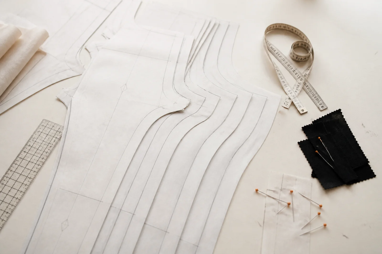 Nested unbranded leggings pattern pieces across several graded sizes with measuring tools and black fabric swatches