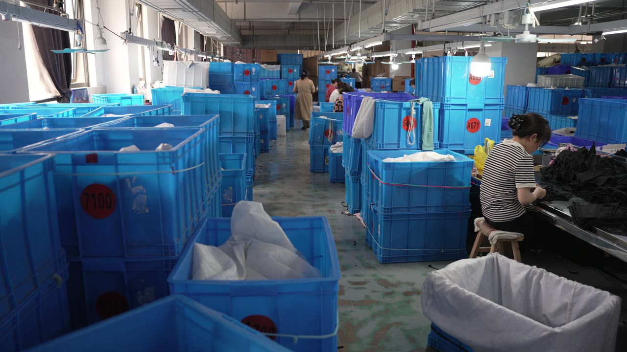 Blue work bins and an operator at a sewing station