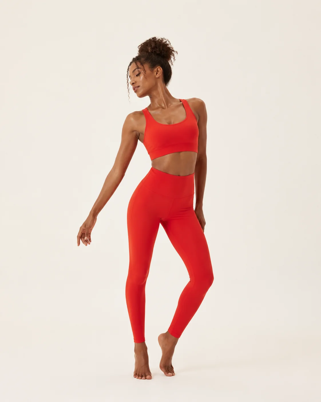 Full-length vermilion yoga set shown in a warm studio