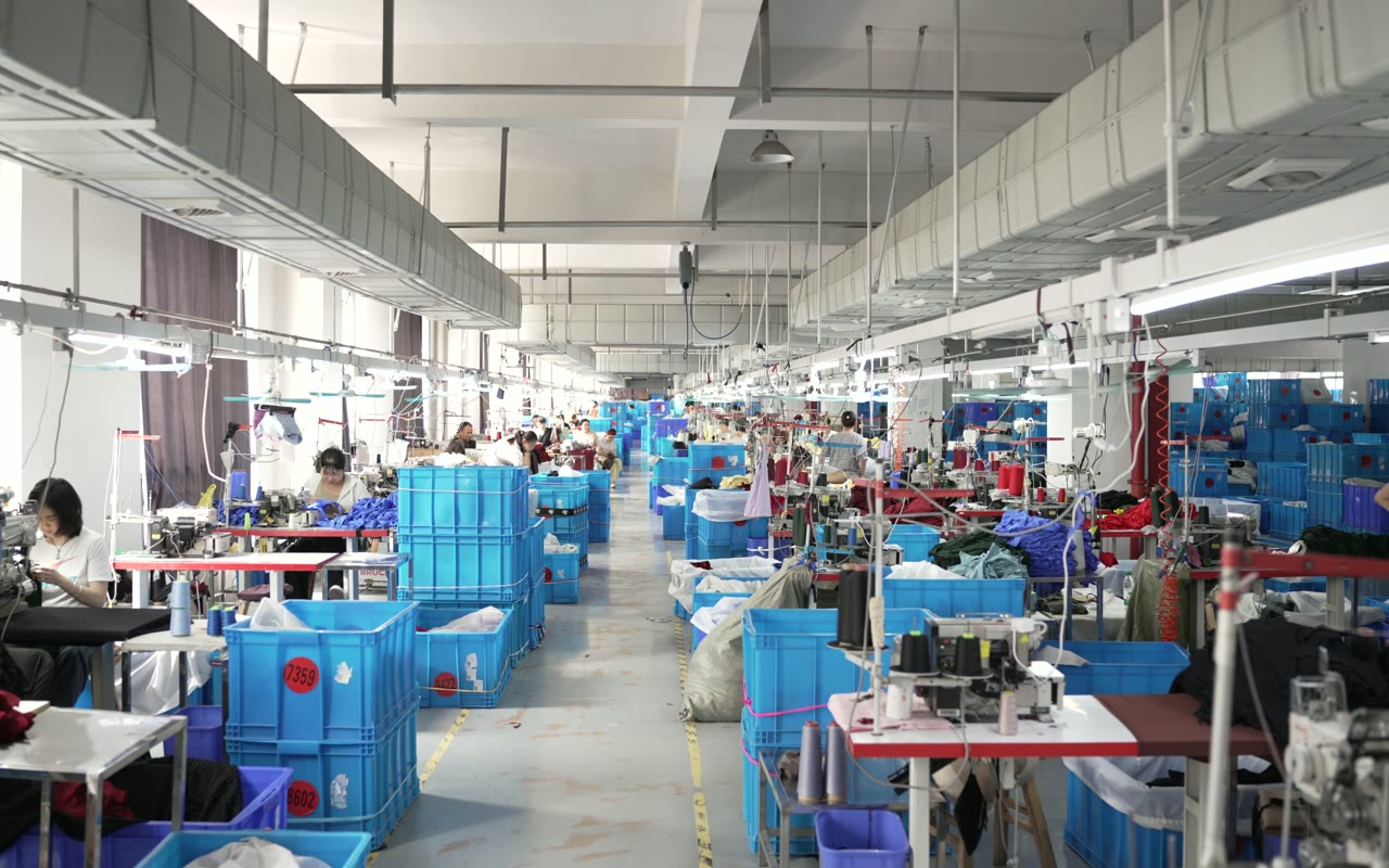 Wide garment production route with sewing stations and organized blue bins