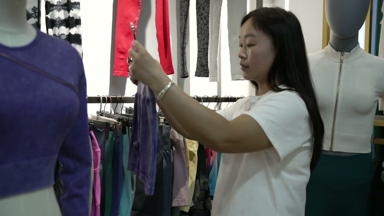 Staff member comparing garment references beside display forms