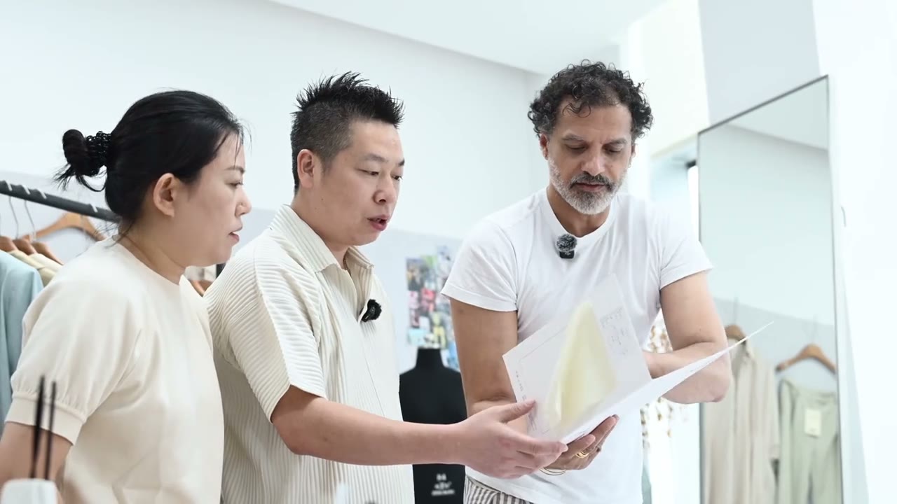 Three people reviewing product documents together in supplied development footage